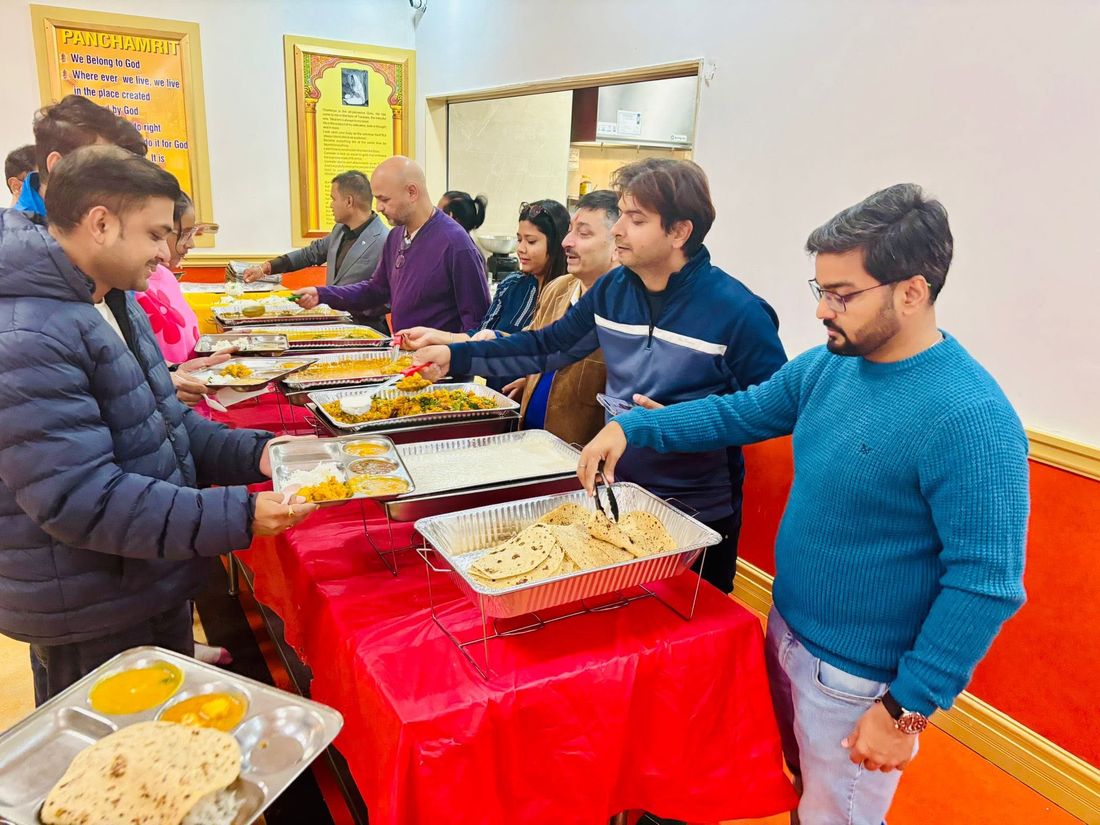 Volunteers serving Preeti Bhoj from the kitchen counter